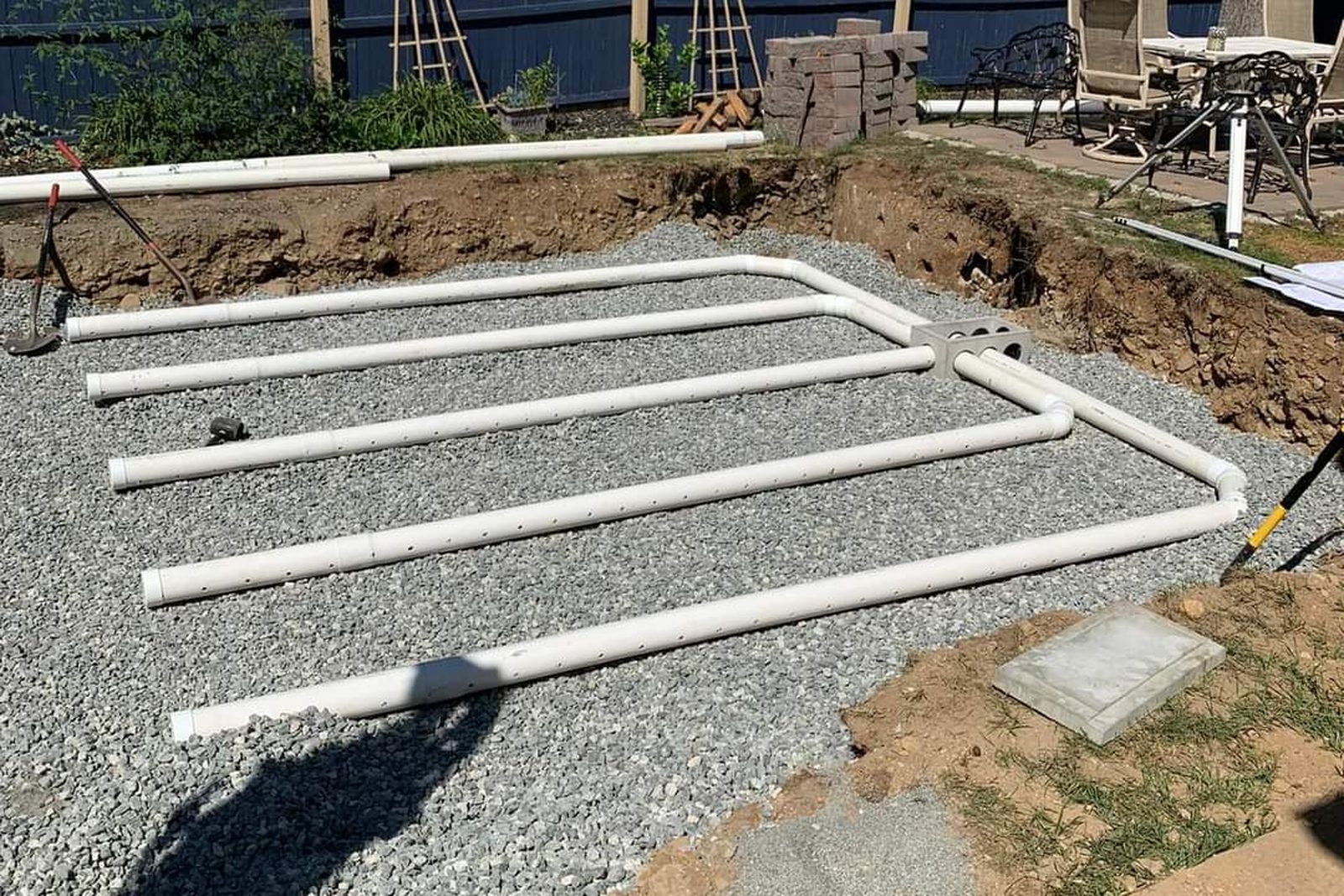 Septic drain lines laid in gravel beside a home