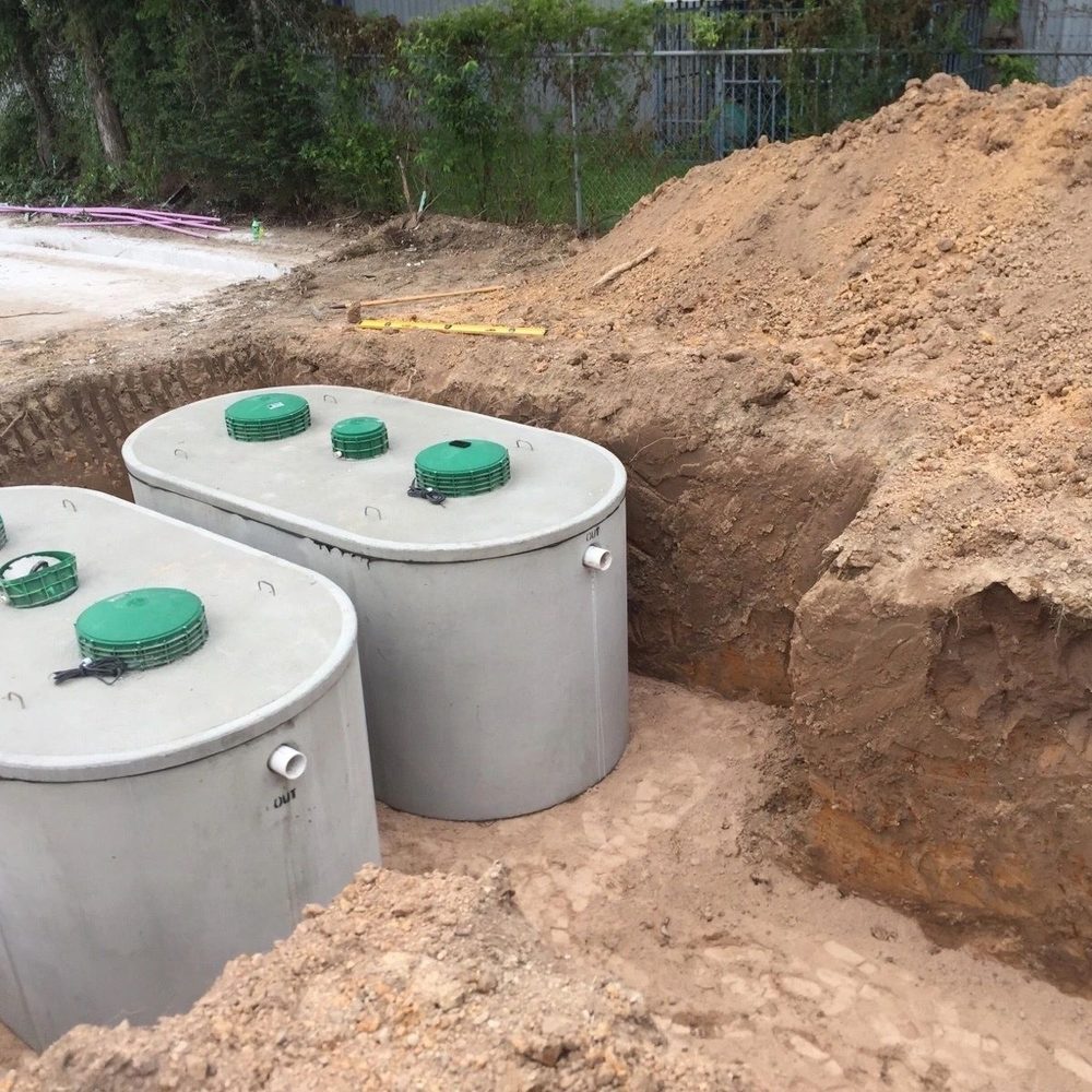 Two concrete septic tanks set in an excavation